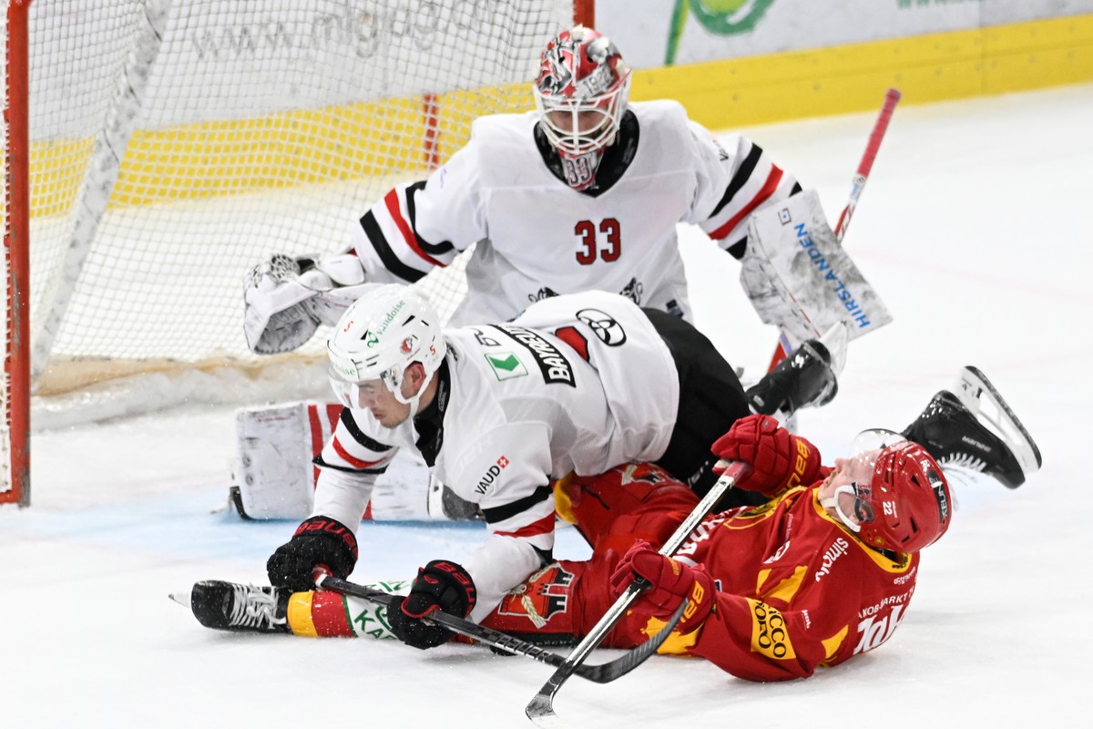 Tigers Joel Salzgeber, rechts, im Kampf um den Puck gegen Lausannes Gavin Bayreuther, links, und Goalie Kevin Pasche, im vierten Eishockey Playoff Viertelfinalspiel der National League, zwischen den S ...