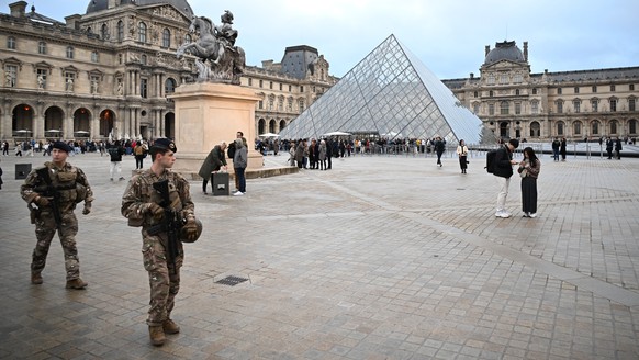 Soldiers patrol as people queue to enter the Louvre museum that remains closed for the day after Sunday&#039;s jewels robbery, Monday, Oct. 20, 2025 in Paris. (AP Photo/Emma Da Silva)
France Louvre