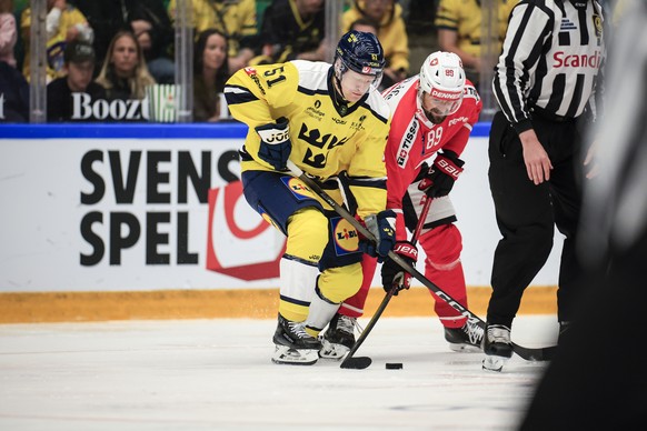 epa12943769 Sweden's Emil Heineman (L) and Switzerland's Fabian Heldner in action during the Beijer Hockey Games match in the Euro Hockey Tour (EHT) between Sweden and Switzerland in Angelho ...