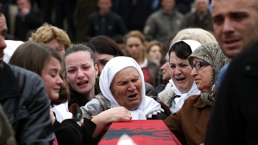 epa04141618 Kosovo Albanians mourn during the reburial ceremony of 19 of 46 Albanians killed by Serb Security forces during the 1998-99 war, in the village of Krusha e Vogel, Kosovo, 26 March 2014. Re ...