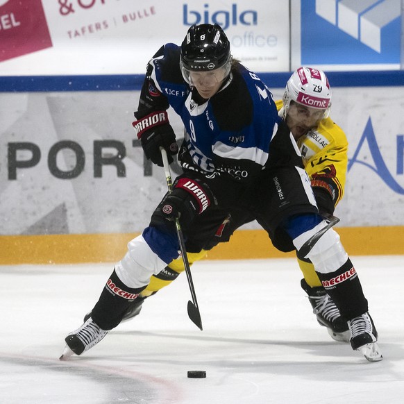 Gotterons Marcus Soerensen, links, und Berns Thierry Bader, rechts, kaempfen um den Puck, beim Eishockey Meisterschaftsspiel der National League A zwischen dem HC Fribourg Gotteron und dem SC Bern, am ...