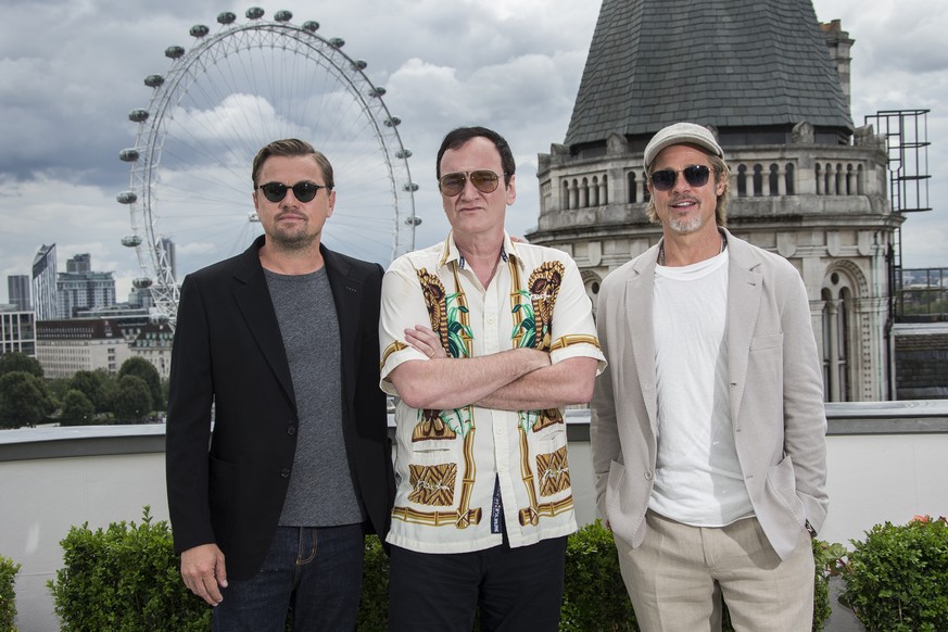 Actors Leonardo DiCaprio, left and Brad Pitt, right, pose for photographers alongside Director Quentin Tarantino, centre, upon arrival at the UK premiere of Once Upon A Time in Hollywood, in London, T ...