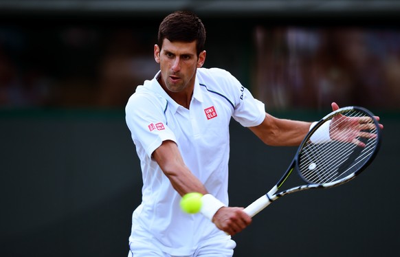 LONDON, ENGLAND - JULY 06: Novak Djokovic of Serbia plays a backhand in his Gentlemen&#039;s Singles Fourth Round match against Kevin Anderson of South Africa during day seven of the Wimbledon Lawn Te ...