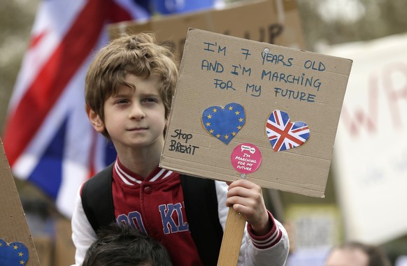 A child on a man&#039;s shoulders carries a poster during a Peoples Vote anti-Brexit march in London, Saturday, March 23, 2019. The march, organized by the People&#039;s Vote campaign is calling for a ...