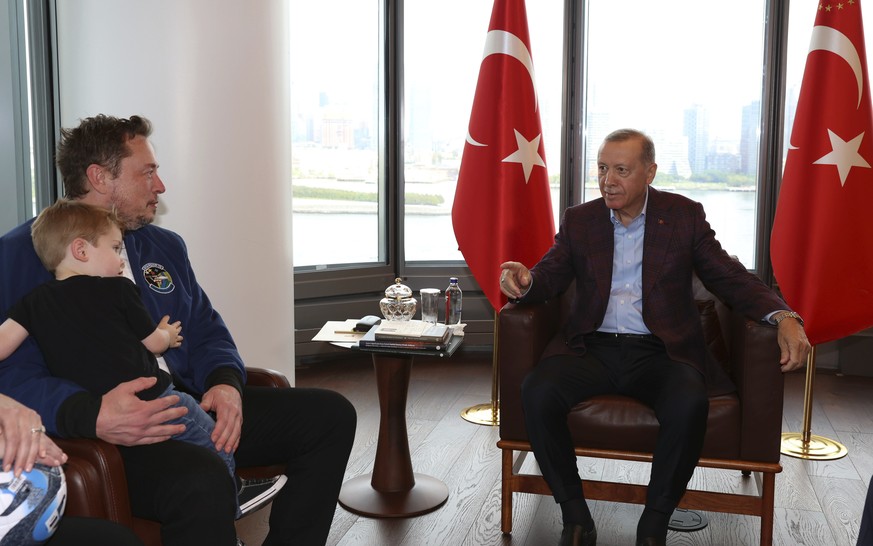 In this handout photo released by Turkish Presidency, Turkish President Recep Tayyip Erdogan, right, talks to Elon Musk, holding one of his sons, during their meeting in New York, Sunday, Sept. 17, 20 ...