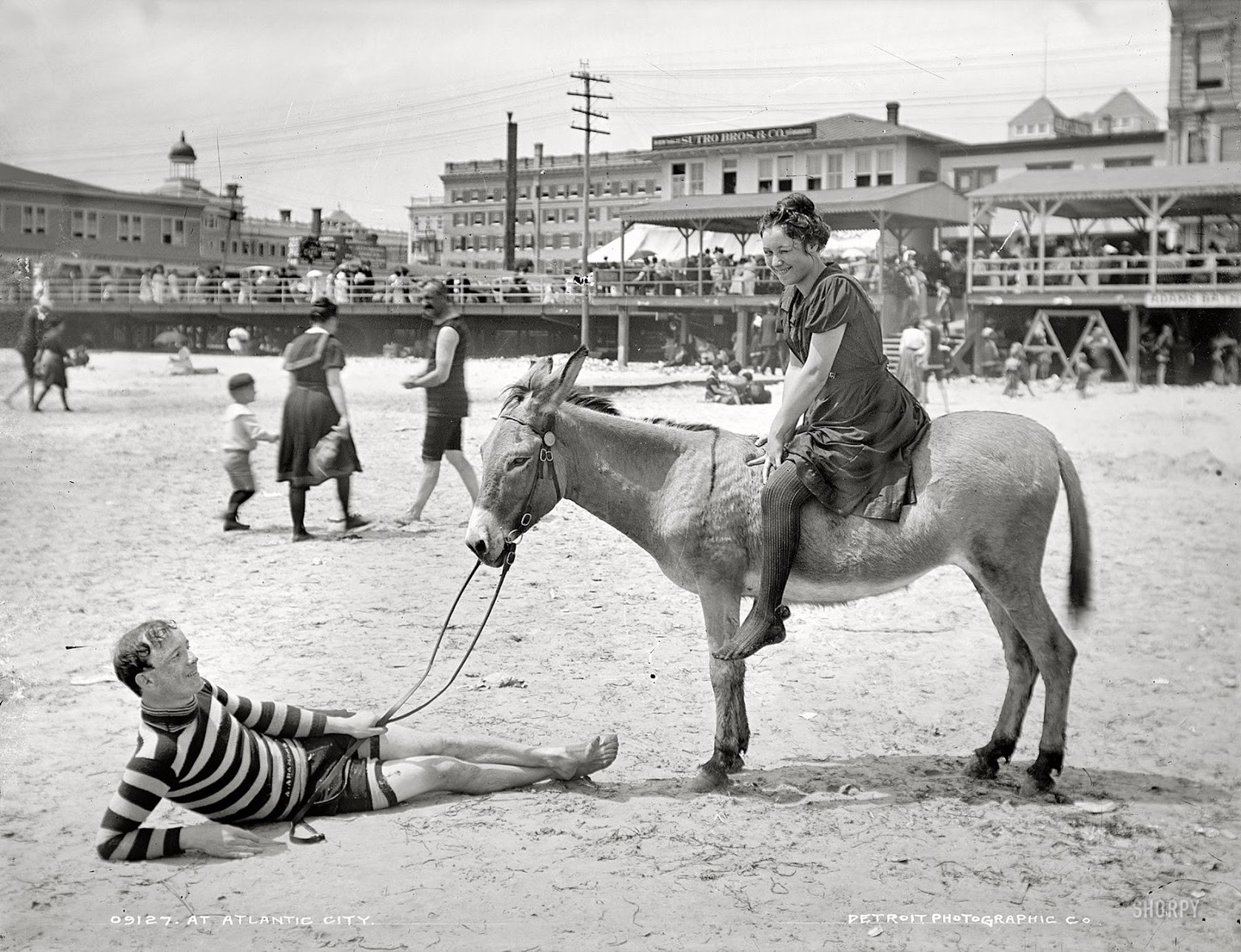 Man and women posed on donkey for photo at crowded beach, Atlantic City, N.J.“
Es zeigt Atlantic City, New Jersey, zwischen 1900 und 1915,