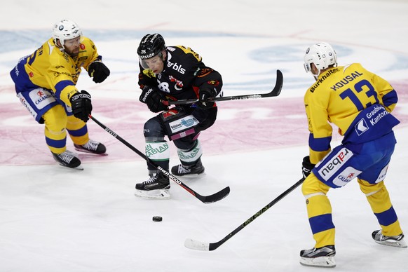 Berns Martin Pluess, Mitte, im Kampf mit den Davosern Robert Kousal, rechts, und Tino Kessler, links, im Eishockey Meisterschaftsspiel der National League A zwischen dem SC Bern und dem HC Davos, am F ...