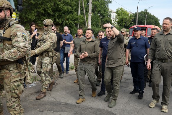 epa10679102 Ukrainian President Volodymyr Zelensky (C-L) speaks to Ihor Klymenko (C-R), head of the National Police of Ukraine, during a visit to Kherson, Ukraine, 08 June 2023, amid the Russian invas ...