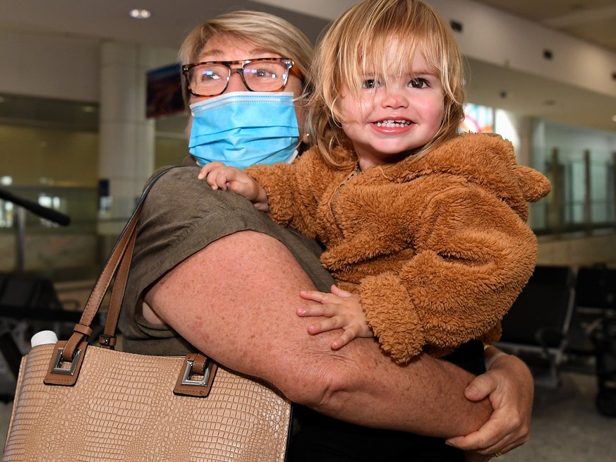 epa09556729 Robert Dapice is reunited with his grandmother Deb Dapice as travellers arriving on the first quarantine free international flights are embraced by family at Sydney International Airport,  ...