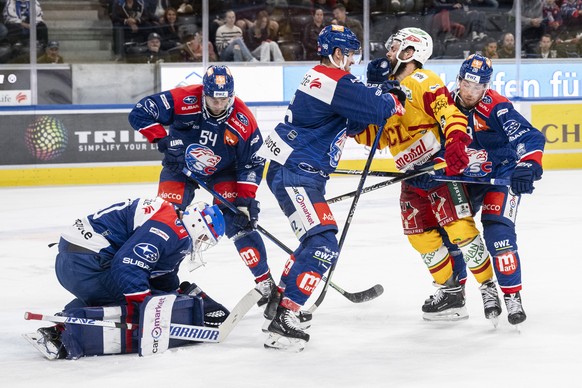Zuerichs Torhueter Simon Hrubec, links, kaempft um den Puck gegen Langnaus Julian Schmutz, rechts, im Eishockeyspiel der National League zwischen den ZSC Lions und den SCL Tigers am Freitag, 13. Oktob ...