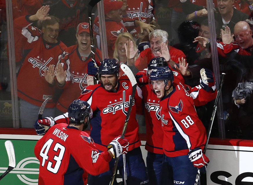 CORRECTS SPELLING OF CAPITALS IN SECOND SENTENCE Washington Capitals left wing Alex Ovechkin (8), from Russia, celebrates scoring a goal against the Pittsburgh Penguins with teammates Tom Wilson (43), ...