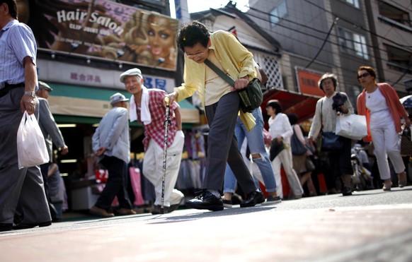 An elderly woman walks through a street full of stores for old people at Sugamo in Tokyo, Wednesday, June 24, 2015. Sugamo is a typical old shopping street with many stalls and shops which serves its  ...