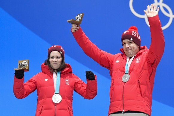 Jenny Perret and Martin Rios of Switzerland (silver medal), left, react next to Kaitlyn Lawes and John Morris of Canada (gold medal), from left, during the victory ceremony on the Medal Plaza for the  ...