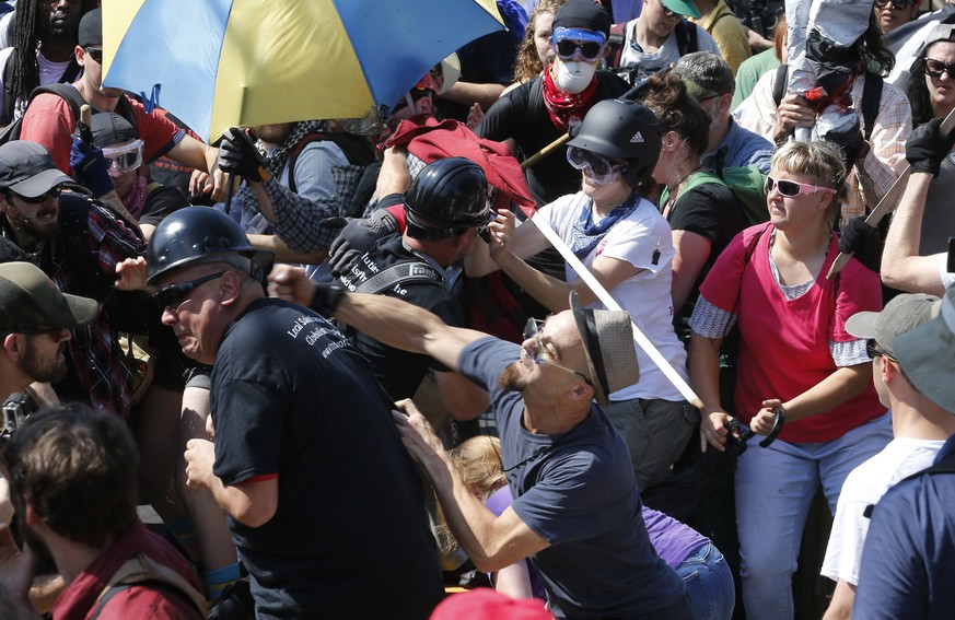 FILE - In this Aug. 12, 2017 file photo, White nationalist demonstrators clash with counter demonstrators at the entrance to Lee Park in Charlottesville, Va. A former federal prosecutor says the law e ...