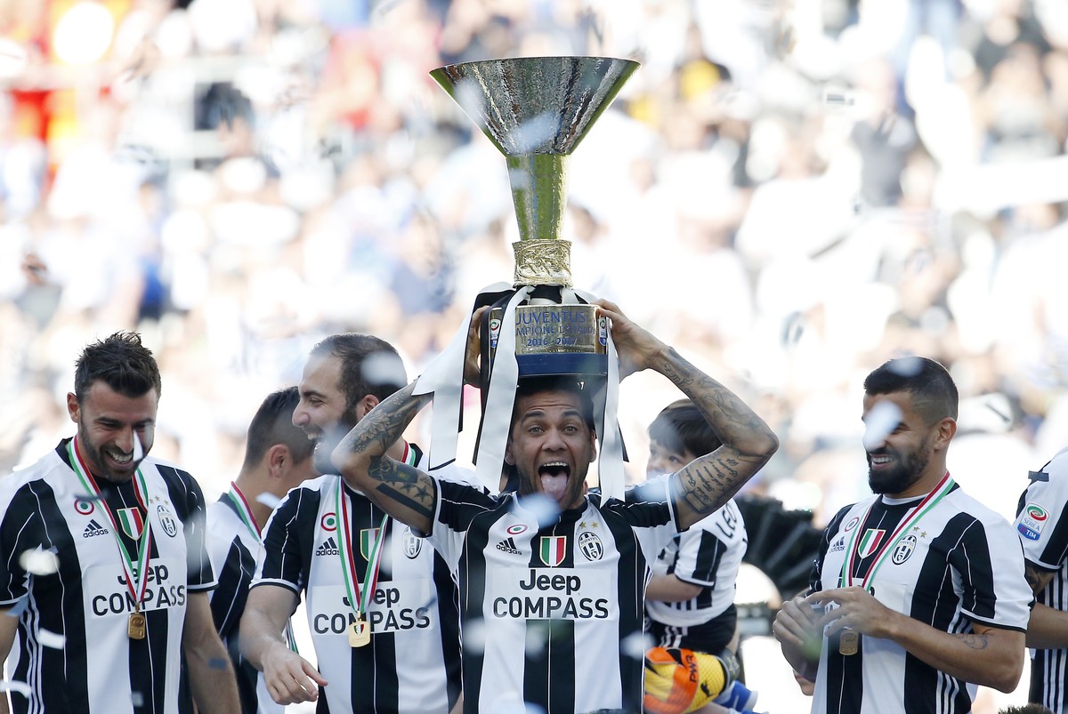 Juventus' Dani Alves lifts the trophy as Juventus players celebrate winning an unprecedented sixth consecutive Italian title, at the end of the Serie A soccer match between Juventus and Crotone a ...