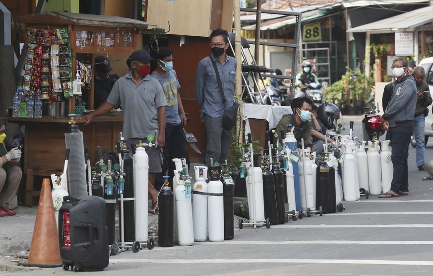 People line up to refill their oxygen tanks at a filling station in Jakarta, Indonesia, Wednesday, July 7, 2021. Indonesia is facing a devastating second wave of coronavirus outbreak as hospitals grap ...