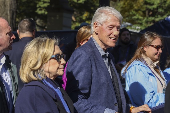 epa12499570 Former US President Bill Clinton (R) and Hillary Clinton (L) wait for their daughter Chelsea Clinton to cross the finish line in the 2025 TCS New York City Marathon at Central Park in New  ...