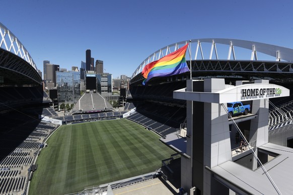 A large LGBTQ Pride flag flutters briefly atop the otherwise empty Seattle Sounders and Seattle Seahawks' stadium after being raised for a photo op Monday, June 22, 2020, in Seattle. The usual LG ...