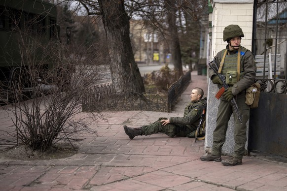 A Ukrainian soldier sits injured after crossing fire inside the city of Kyiv, Ukraine, Friday, Feb. 25, 2022. Russia pressed its invasion of Ukraine to the outskirts of the capital Friday after unleas ...