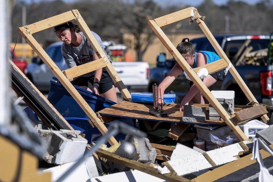 epa10543600 Brittany Pace (L) and Rami Kate Pace (R) look through the debris of the Amory High School baseball press box and coach&#039;s office the day after a tornado in Amory, Mississippi, USA, 25  ...