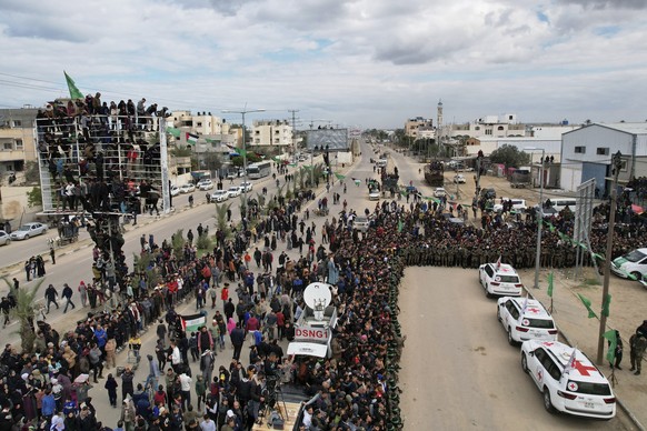 International red cross cars wait for Israeli captives, Ohad Ben Ami, Eli Sharabi and Or Levy, who have been held hostage by Hamas in Gaza since October 7, 2023, in Deir al-Balah, central Gaza Strip,  ...