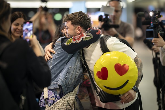 Nunu Mtiraoui, right, is hugged by his mother Sandra Strasser, center, after arriving at Zurich International Airport after a special flight operated by Swiss International Airlines from Muscat, Oman, ...