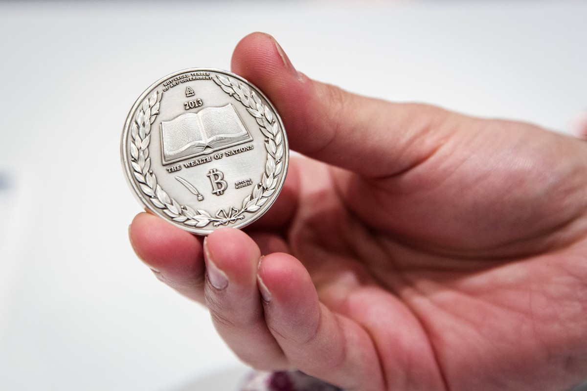 A man holds a Silver coin etched with the cryptographic information for digital Bitcoins in it during the "Inside Bitcoins: The Future of Virtual Currency Conference" in New York in this Apr ...