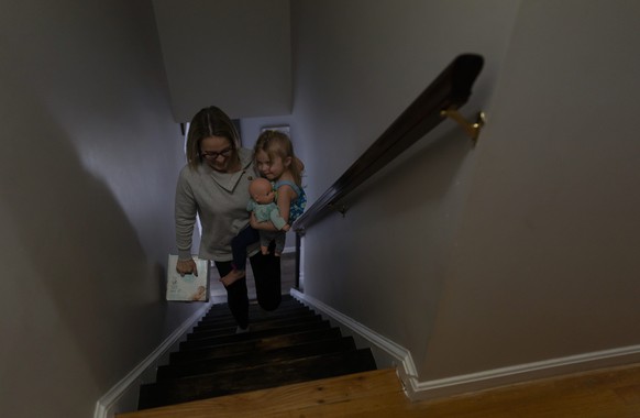 Tara Carpenter carries her daughter, Alyssa Carpenter, 2, and a box of diapers upstairs at their home in Haymarket, Va., Friday, Jan. 28, 2022. Alyssa has had COVID-19 twice and suffers long-term symp ...