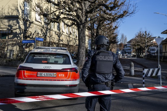 Ein Polizist bewacht das Gebiet wegen eines Alarmes an der Munzingerschule, am Dienstag, 19. Dezember 2023, in Bern. (KEYSTONE/Peter Schneider)