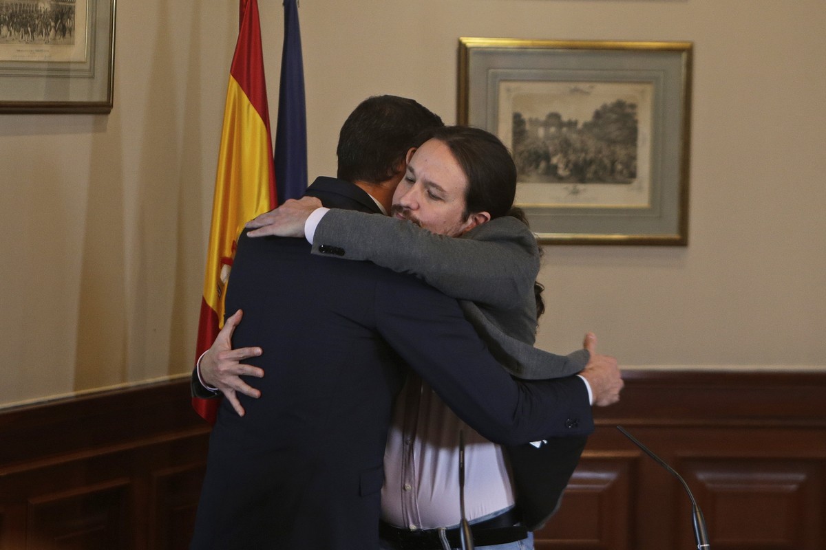 Spain's caretaker Prime Minister Pedro Sanchez, left, and Podemos party leader Pablo Iglesias hug after signing an agreement at the parliament in Madrid, Spain, Tuesday, Nov. 12, 2019.The leaders ...