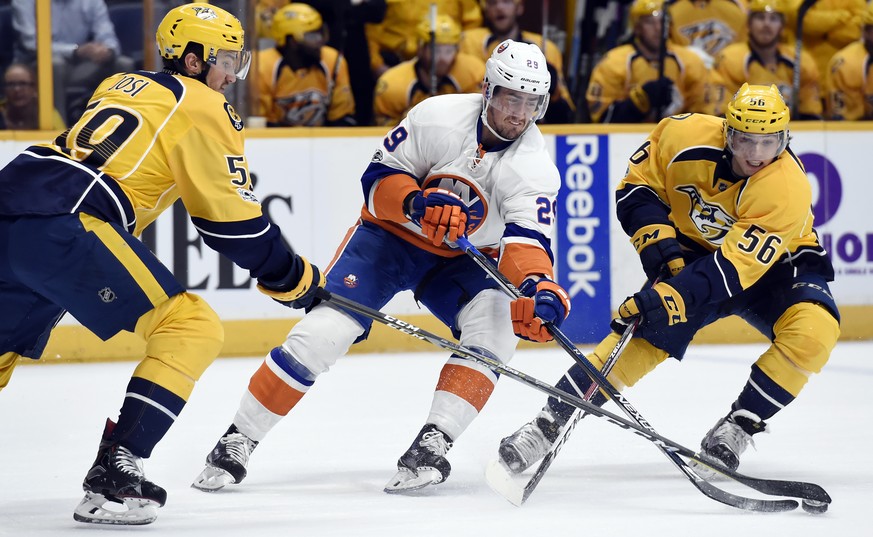 New York Islanders center Brock Nelson (29) maneuvers the puck between Nashville Predators defenseman Roman Josi (59), of Switzerland, and left wing Kevin Fiala (56), of the Czech Republic, during the ...