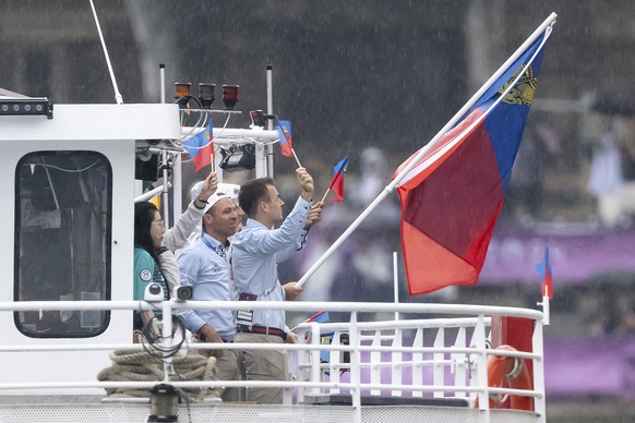 Liechtenstein's flag-bearer mountainbiker Romano Puentener celebrates on a boat during the opening ceremony of the 2024 Paris Summer Olympics on the Seine river in Paris, France, Friday, July 26, ...