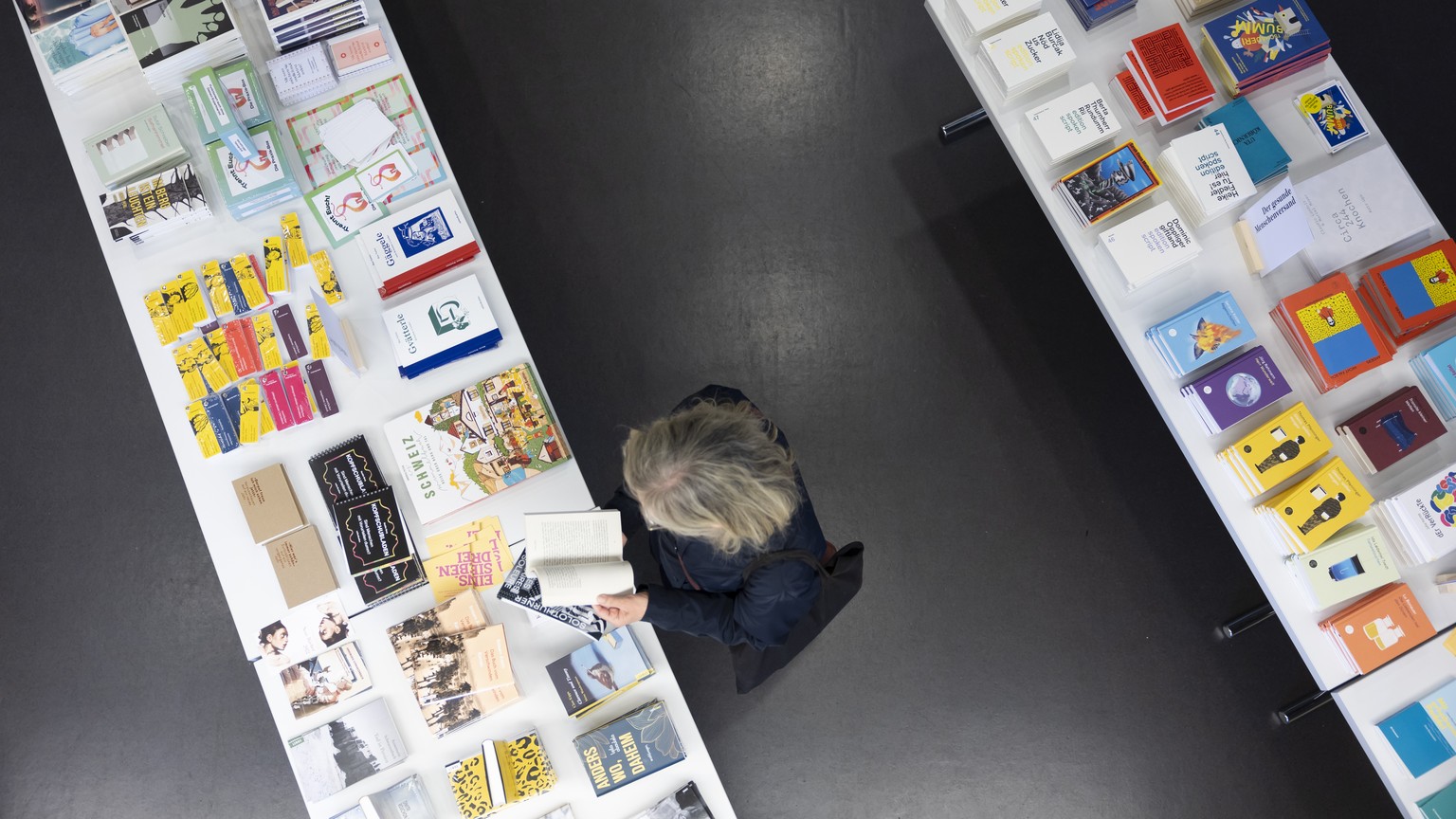 Eine Besucherin blaettert an einem Buechertisch in einem Buch, waehrend den 45. Solothurner Literaturtagen, am Freitag, 19. Mai 2023 in Solothurn. (KEYSTONE/Peter Klaunzer)