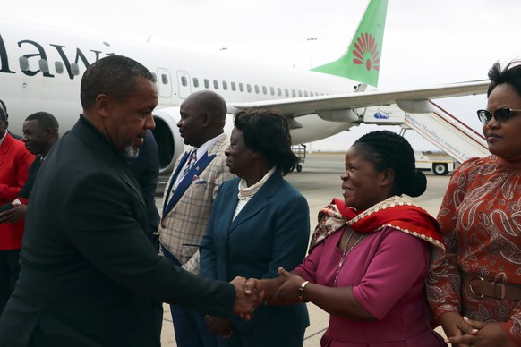 Malawi Vice President Saulos Chilima, left, greets government officials upon his return from South Korea in Lillongwe, Sunday, June 9, 2024. A military plane carrying Malawi&#039;s vice president and  ...