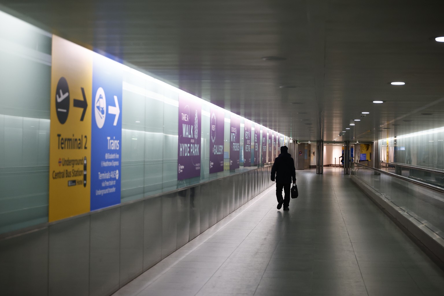epa11977963 A person walks in the tunnel towards the Underground Station in Terminal 2 at Heathrow Airport in Hillingdon, London, Britain, 21 March 2025. Heathrow Airport on 21 March announced it woul ...