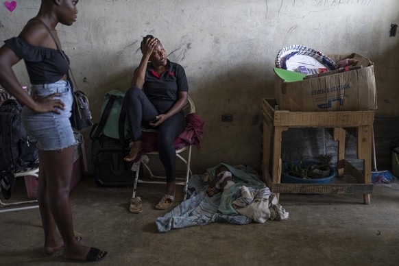Elise Messadien cries as she sits next to the body of her 1-year-old goddaughter, who is believed to have died of dehydration, at a shelter for people displaced by gang violence, in Port-au-Prince, Ha ...