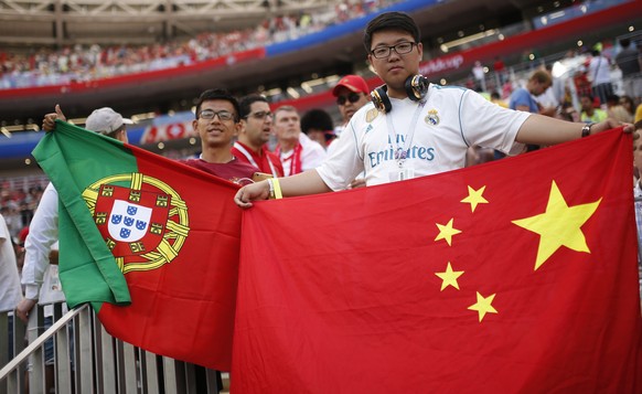 Fans display flags of China, right, and Portugal, left, prior the group B match between Portugal and Morocco at the 2018 soccer World Cup in the Luzhniki Stadium in Moscow, Russia, Wednesday, June 20, ...