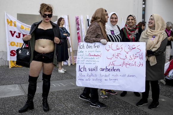 Eine Frau zeigt ihren Bauch mit der Aufschrift &quot;I GAVE LIFE&quot; neben vier muslimischen Frauen mit Kopfuechern, die mit einem Schild fuer ihre Freiheit auf das Tragen eines Kopftuches plaedieren, am nationalen Frauenstreik am Freitag, 14. Juni 2019, in Luzern. Am heutigen Freitag findet in der Schweiz der Frauenstreik statt. Der Kampftag für die Gleichstellung der Geschlechter ist dezentral organisiert und geht an vielen Orten mit mannigfaltigen Aktionen ueber die Buehne. (KEYSTONE/Alexandra Wey)