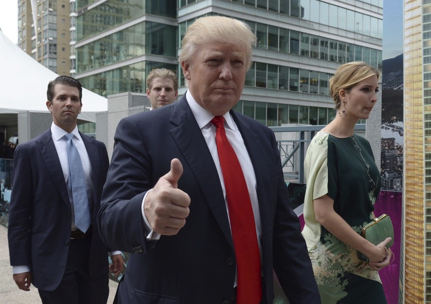 In this June 19, 2013 photo, Donald Trump signals thumbs up as he arrives with his children Donald Jr., Eric and Ivanka to announce the building of Trump International Hotel and Tower in downtown Vanc ...