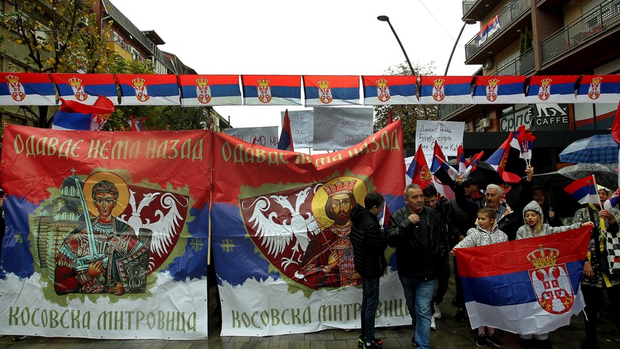 epa10290173 People walk past banners reading 'No turning back from here, Kosovska Mitrovica' during a rally in Northern Mitrovica, Kosovo, 06 November 2022. Kosovo Serbs protested after a dispute over ...