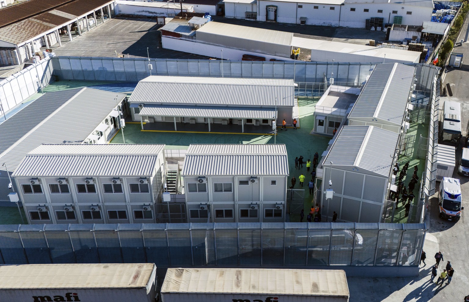 An aerial view of a migrant reception facility at the port of Shengjin, northwestern Albania, Friday, Nov. 8, 2024, before a second group of eight migrants intercepted in international waters is proce ...