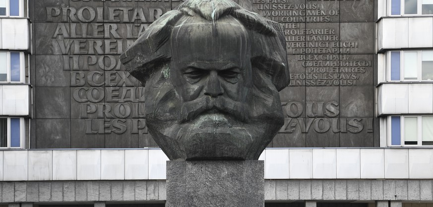 epa06976827 Right wing protesters in front of a statue of Karl Marx (C) at the place where a man was stabbed overnight 25 August 2018, in Chemnitz, Germany, 27 August 2018. A 35-year-old man reportedl ...