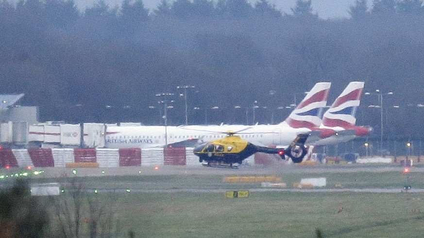 A police helicopter flies over Gatwick Airport as the airport remains closed after drones were spotted over the airfield last night and this morning, in Gatwick, England, Thursday, Dec. 20, 2018. Dron ...