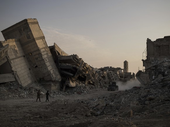 Iraqi soldiers walk in a damaged street as Iraqi forces continue their fight against Islamic State militants in parts of the Old City of Mosul, Iraq, Sunday, July 9, 2017. (AP Photo/Felipe Dana)