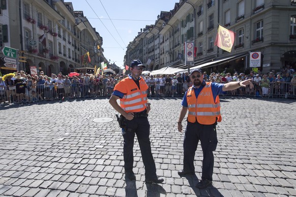 Spectactors and policemen await the pack of cyclers at the &quot;Nydeggstalden&quot; hill in the old town of Berne, during the 16th stage of the 103rd edition of the Tour de France cycling race over 2 ...
