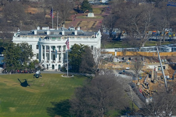 Marine One helicopter, with President Donald Trump aboard, left, lifts from the South Lawn and work continues on the construction of the ballroom at the White House, Tuesday, Jan., 13, 2026, in Washin ...
