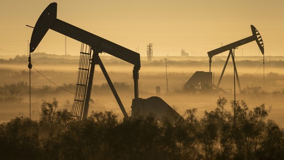 Fog blankets a low-lying area where pumpjacks operate in West Texas, northeast of Kermit, on Sept. 12, 2018. In December 2017, companies in the Permian Basin _ an ancient, oil-rich seabed that spans W ...