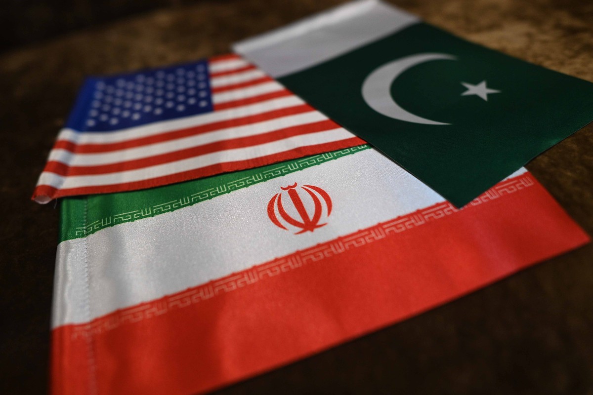 epa12896941 A shopkeeper displays Iranian, US and Pakistani flags at a shop in Karachi, Pakistan, 17 April 2026. Pakistan has emerged as a key venue for diplomacy between the United States and Iran, w ...