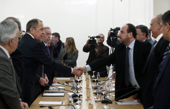 epa06465512 Russian Foreign Minister Sergei Lavrov (L) shakes hands with Head of Syrian opposition delegation Nasr Hariri (R) during their meeting in Moscow, Russia, 22 January 2018. A delegation of S ...