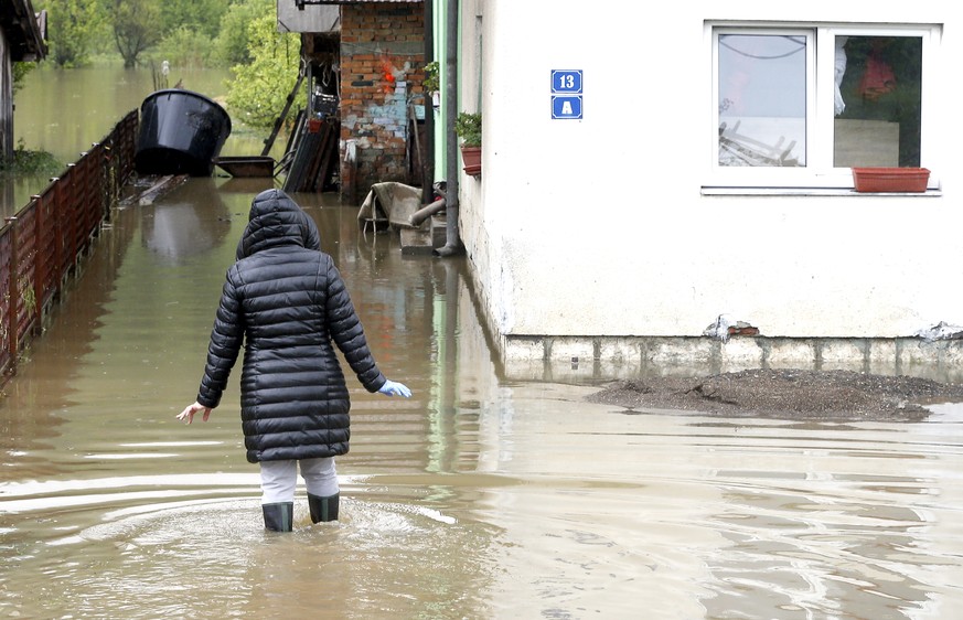 epa07570040 A woman enters a flooded house in Teslic in central Bosnia, during the floods in Bosnia and Herzegovina, 14 May 2019. The region was hit by heavy rains, causing flooding in several areas.  ...